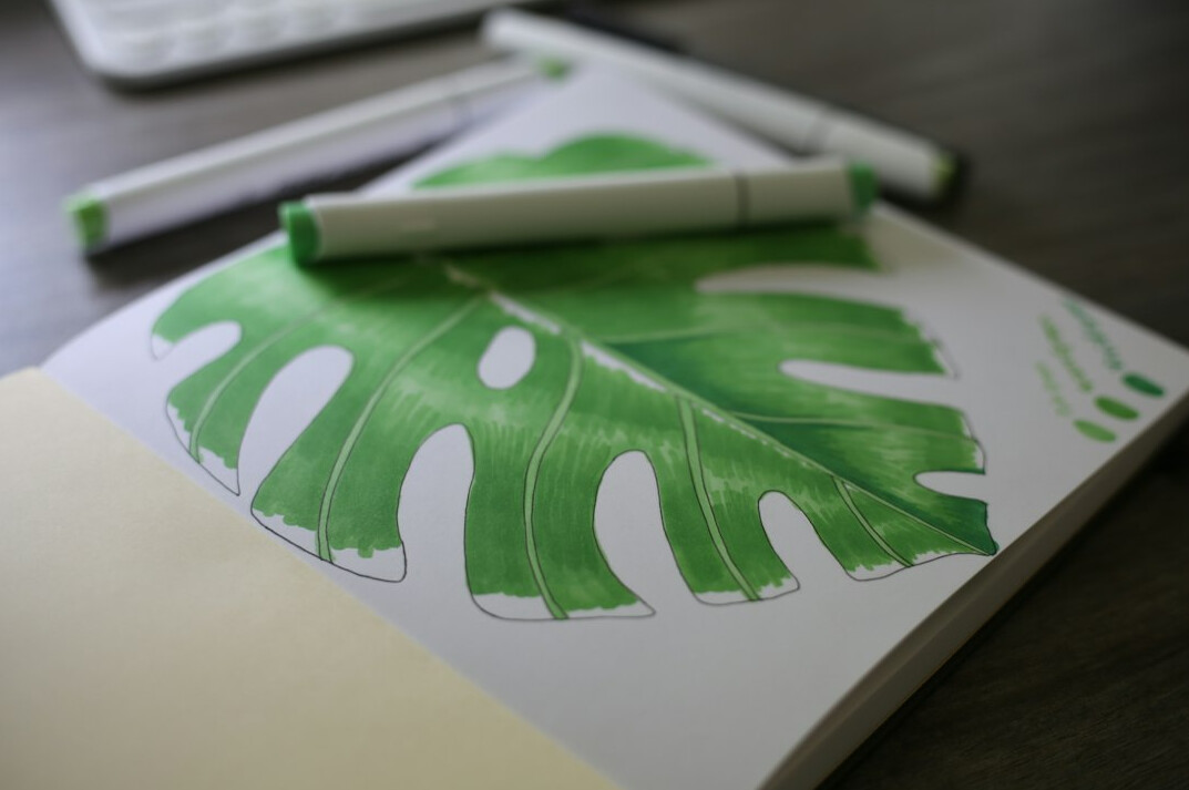 Open notebook with a pen lying on a wooden table